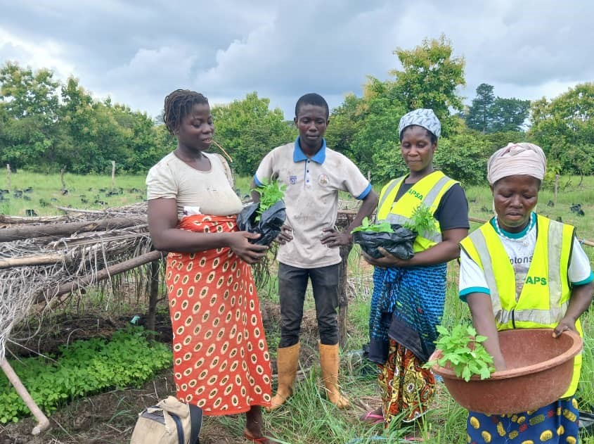 Femmes et équipe APSA présentant de jeunes plants lors d’une formation pratique