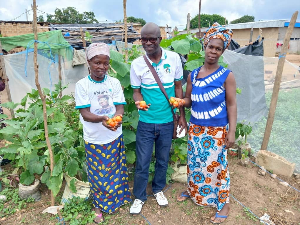 Bénéficiaires et membre d’APSA présentant une récolte d’aubergines