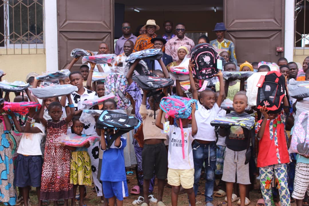Enfants présentant les kits scolaires reçus
